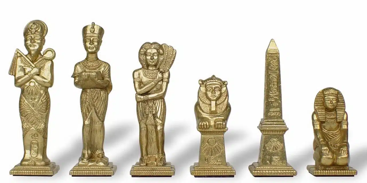 Detal złotych figur, postacie egipskie i grawerowany obelisk