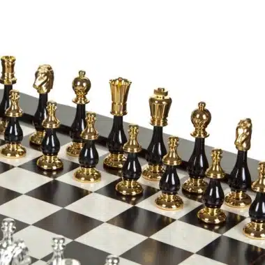 Detal złotych i czarnych figur ustawionych na szachownicy z jasnego i ciemnego drewna