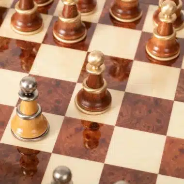 Detal pól z lakierowanego wrzosowca i drewnianych pionów na szachownicy