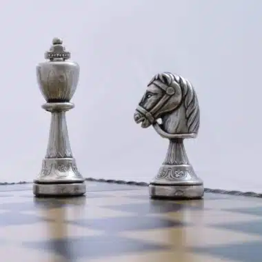 Srebrny król naprzeciw skoczka, detal masywnych metalowych figur