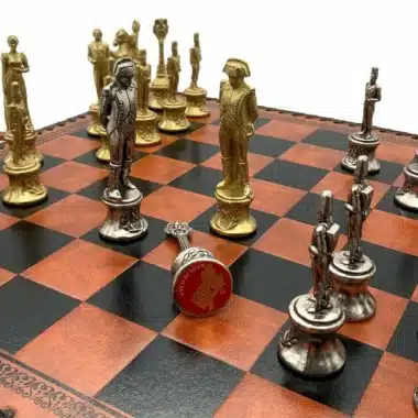 Zbliżenie złotych i srebrnych figur naprzeciw siebie na szachownicy