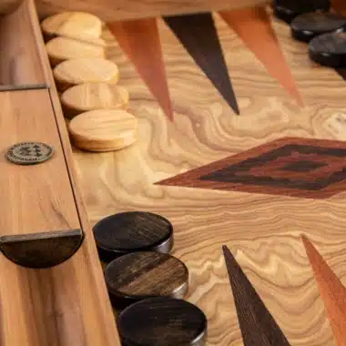 Backgammon z drewna oliwnego, detal jasnych i ciemnych pionków na intarsjowanych strzałkach