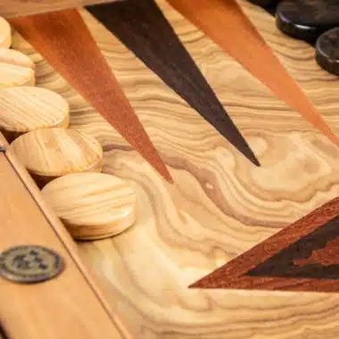 Backgammon z drewna oliwnego, zbliżenie na intarsjowane strzałki i boczną krawędź