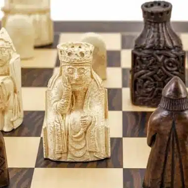 Jasny hetman z wyspy Lewis naprzeciw ciemnych figur na szachownicy