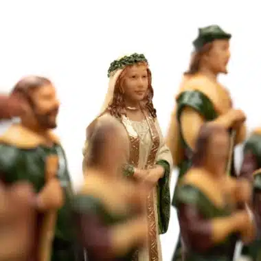Figurka damy, królowej w białej i zielonej sukni, pośród figur Robin Hood