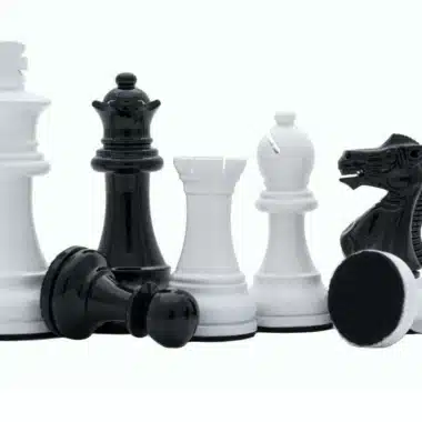 Grupa czarnych i białych figur z rzeźbionym skoczkiem w zbliżeniu