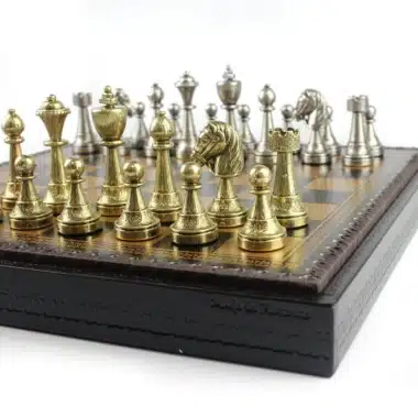 Detal masywnych złotych i srebrnych figur metalowych na grawerowanej krawędzi szachownicy
