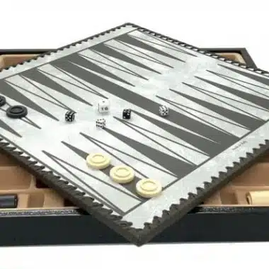 Plansza do backgammona w szarości i czerni z pionami i kostkami ułożonymi na kasecie