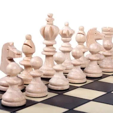 Detal jasnych drewnianych figur ustawionych na szachownicy