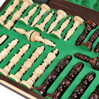 Pièces d'échecs en bois sculpté rangées dans leur coffret doublé de feutrine verte