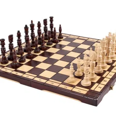 Jeu d'échecs en bois sculpté posé sur échiquier pliant ouvert