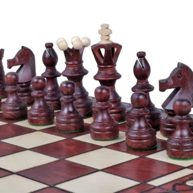 Szczegóły rzeźbionych czerwonych figur ustawionych na szachownicy z intarsją