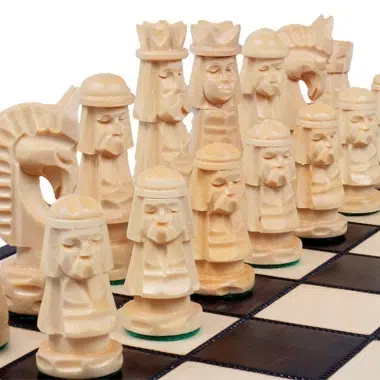 Rząd jasnych rzeźbionych figur widziany z bliska na szachownicy
