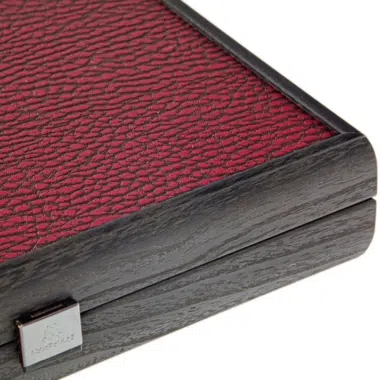 Bordowy podróżny backgammon, szczegół drewnianego narożnika i metalowego zamka