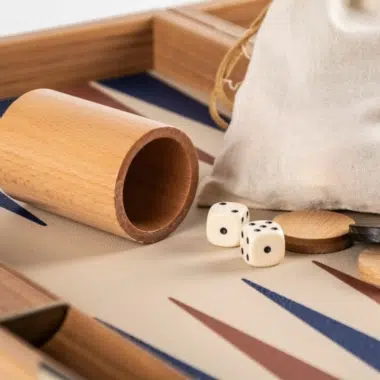 Backgammon ze skóry ekologicznej w kolorze beżowym szampańskim, szczegół drewnianego kubka do kostek i woreczka z tkaniny
