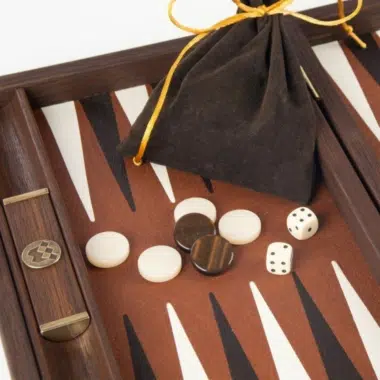 Szczegół rogu planszy z woreczkiem z tkaniny i pionkami do backgammona