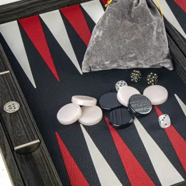 Szczegół pionków, kości i woreczka z szarego welwetu na planszy do backgammona