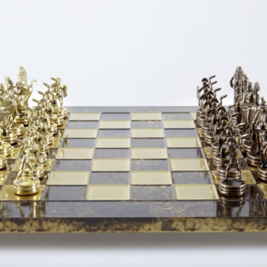 Metalowa szachownica ze złotymi i srebrnymi figurami naprzeciw siebie, widok z przodu