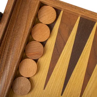 Backgammon dębowo-orzechowy, zbliżenie na jasne pionki ułożone na schowku