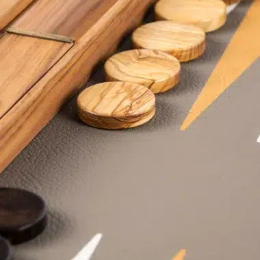 Backgammon, detal jasnych drewnianych pionków ustawionych na krawędzi kasety