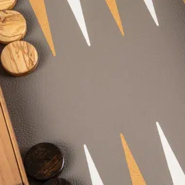 Backgammon, zbliżenie na białe i złote strzałki na planszy z ekoskóry