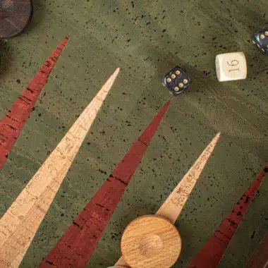 Zbliżenie na kości leżące na zielonej planszy korkowej backgammona