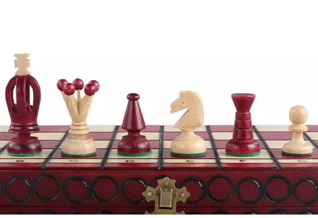 Détail de quatre pièces d'échecs posées sur le bord du coffret fermé