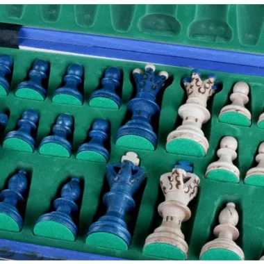 Pièces d'échecs bleues et ivoire rangées dans leur coffret de rangement vert