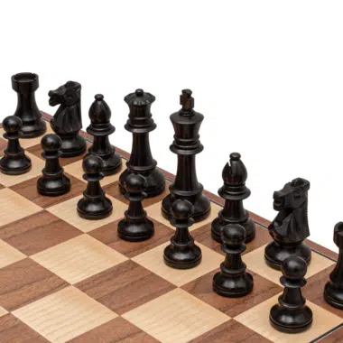 Czarne figury Staunton Conquest ustawione na szachownicy z orzecha i klonu
