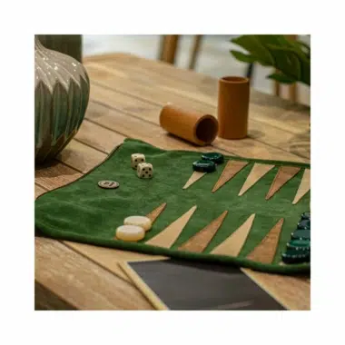 Zwijany backgammon z zielonego zamszu, w aranżacji na drewnianym stole