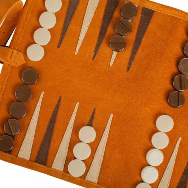 Szczegół pionków i segmentów na zwijanej planszy backgammona z brązowego zamszu, harmonijna estetyka