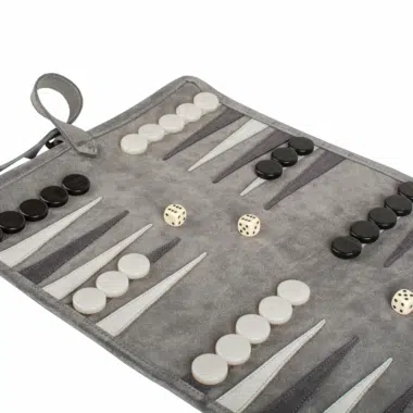 Backgammon zwijany z zamszu w kolorze leśnej zieleni z pionkami i kośćmi na stole - przytulna atmosfera