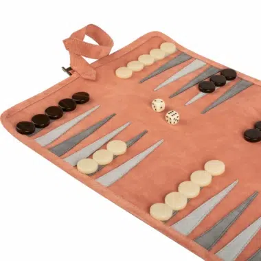 Bliski kadr na planszę Backgammon z zamszu w kolorze łososiowym, pionki i kości
