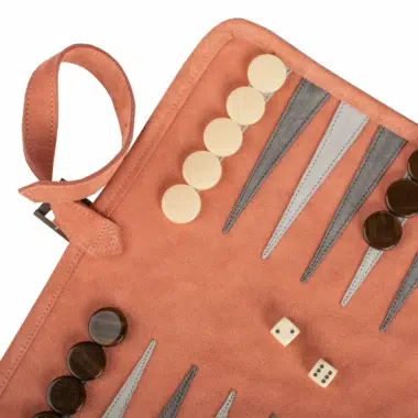 Detal planszy Backgammon z zamszu w kolorze łososiowym, pionki dobrze ułożone