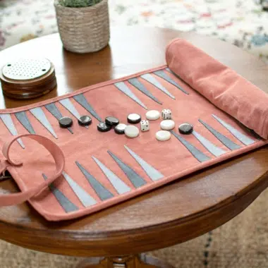 Zestaw Backgammon z zamszu w kolorze łososiowym na stole, przytulna atmosfera - Le Palais Des Echecs