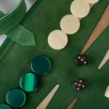 Zbliżenie na pionki backgammon z zamszu w kolorze leśnej zieleni i kości do gry