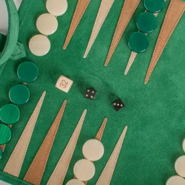 Bliski kadr na pionki backgammon z zamszu w kolorze leśnej zieleni, przytulna atmosfera